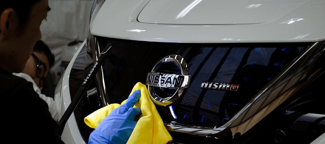 NISSAN LEAFにKUBEBOND DIAMOND9H ナノセラミックコーティング施工中にムラがないかLEDライトでチェックするスタッフ