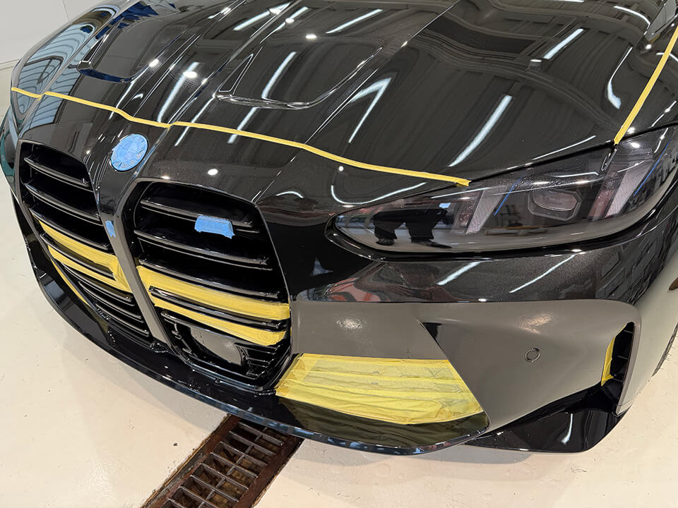 研磨のためにマスキングをしたBMW M3 Competition Touringのフロント